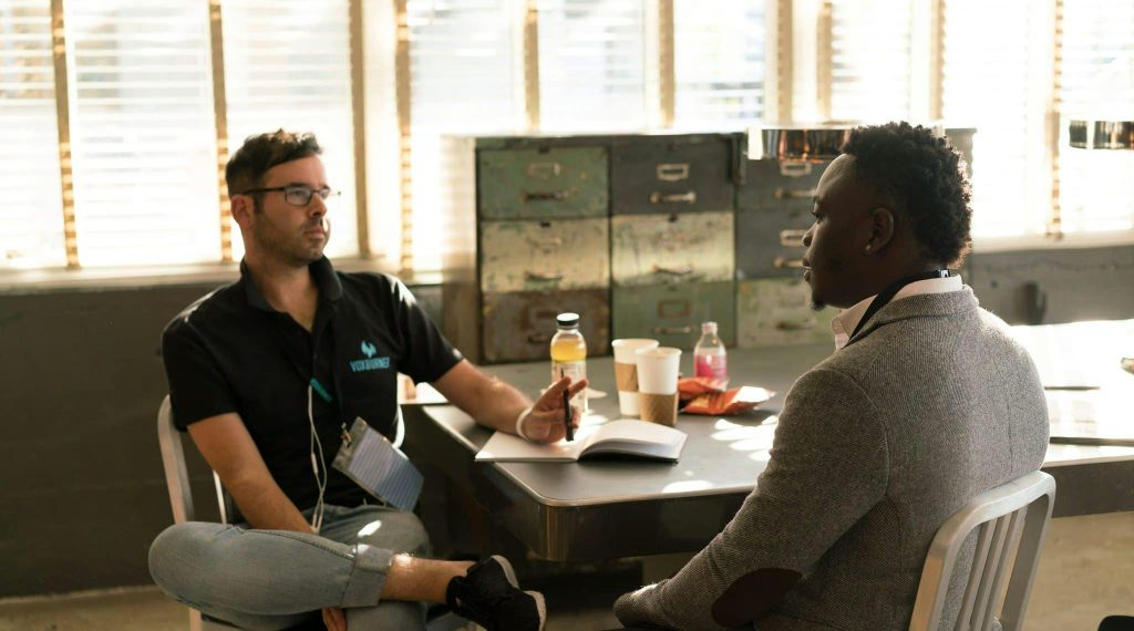 Two men having a focused business discussion in a sunlit office space.