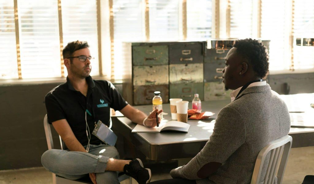 Two men having a focused business discussion in a sunlit office space.